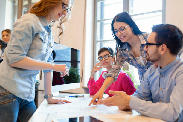 4 formateurs en formation qui échangent autour d'une table de travail