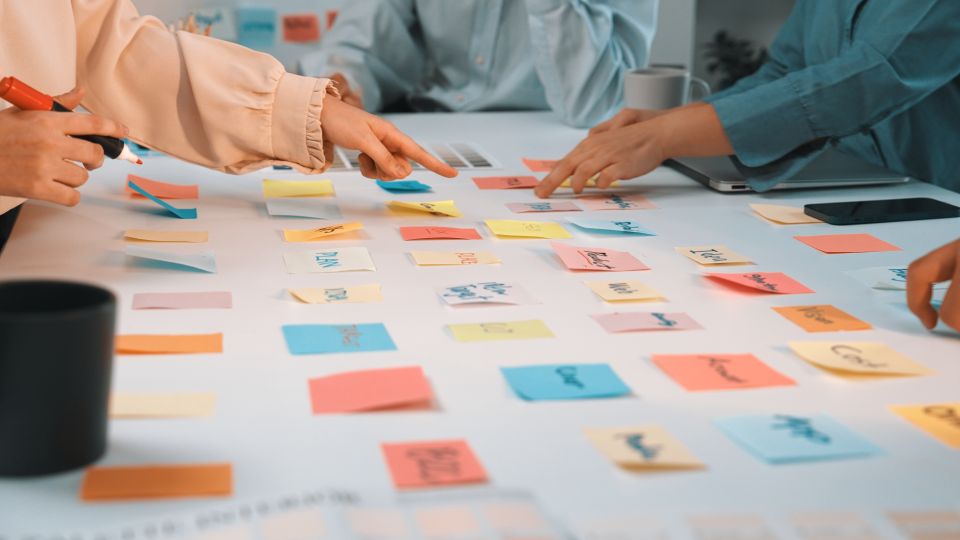 Groupe de personnes utilisant une technique de brainstorming collaboratif avec des post-its