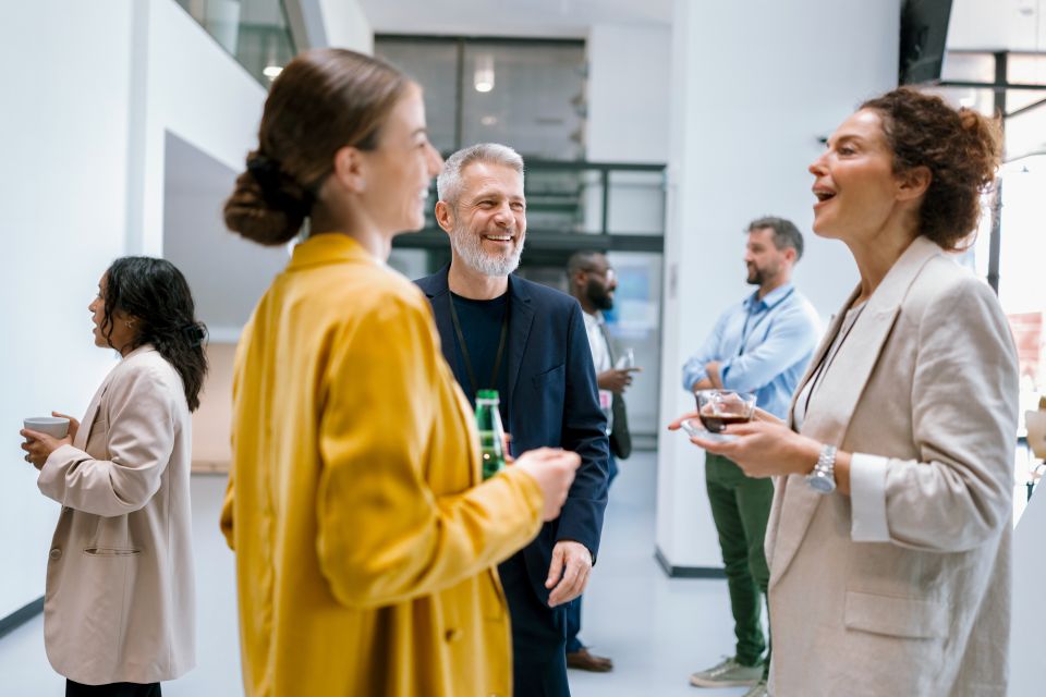 Professionnels échangeant de manière informelle lors d’un événement ou d’une rencontre réseau.